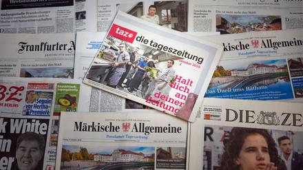 Die letzte Printausgabe der Zeitung „taz“ vom 17. Oktober 2025 liegt auf einem Tisch zwischen anderen Zeitungen. 