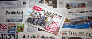 Die letzte Printausgabe der Zeitung „taz“ vom 17. Oktober 2025 liegt auf einem Tisch zwischen anderen Zeitungen. 