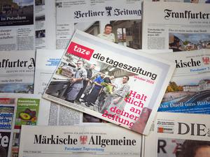 Die letzte Printausgabe der Zeitung „taz“ vom 17. Oktober 2025 liegt auf einem Tisch zwischen anderen Zeitungen. 