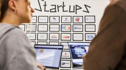 Junge Leute vor einer Tafel mit Start-up-Firmen