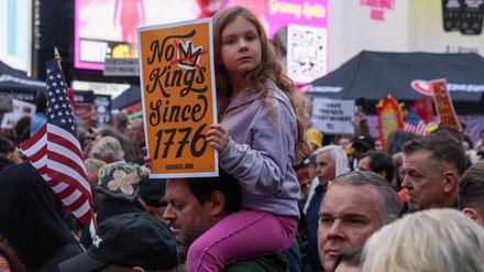 Ein Mädchen hält während einer „No Kings“-Demonstration auf dem Times Square in New York ein Plakat hoch.