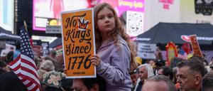 Ein Mädchen hält während einer „No Kings“-Demonstration auf dem Times Square in New York ein Plakat hoch.