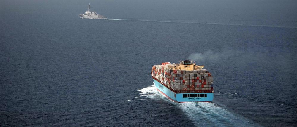 Der US-Lenkwaffenzerstörer USS Chung-Hoon (l hinten) begleitet ein Handelsschiff, das mit Containern beladen ist, während einer Übung im Golf von Aden zum Schutz des freien Handels.