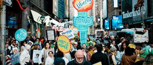 Demonstranten schieben bei den No Kings-Protesten eine Pappfackel die 7th Avenue in Manhattan entlang.
