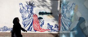 Eine Frau in Teheran vor einem antiamerikanischen Wandbild.