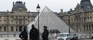 Französische Polizeibeamte stehen nach einem Raubüberfall vor dem Louvre-Museum in Paris am 19. Oktober 2025. 