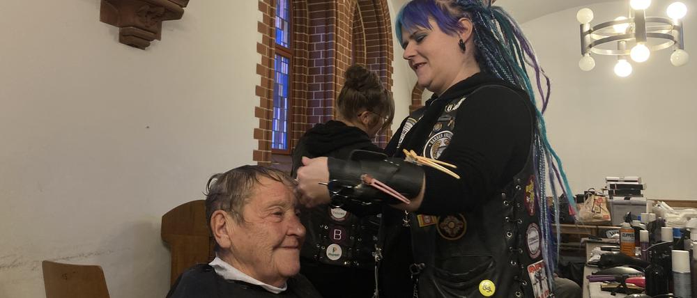 "Barber Angel" Anni schneidet einem Gast kostenlos die Haare in der Pauluskirche.