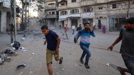Menschen suchen nach einem israelischen Angriff auf ein Gebäude im Flüchtlingslager Bureij im zentralen Gazastreifen am 19. Oktober 2025 Schutz.