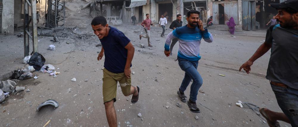 Menschen suchen nach einem israelischen Angriff auf ein Gebäude im Flüchtlingslager Bureij im zentralen Gazastreifen am 19. Oktober 2025 Schutz.