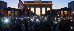 Demonstranten halten ihre Handys mit Taschenlampen vor dem Brandenburger Tor in die Luft. Die Demonstration unter dem Motto «Brandmauer hoch! Wir sind das Stadtbild» bezieht sich auf eine Äußerung von Bundeskanzler Merz im Zusammenhang mit der Migrationspolitik.