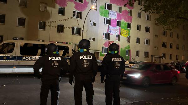 Einsatzkräfte der Polizei stehen vor dem Mehrfamilienhaus in der Habersaathstraße. 