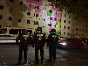 Einsatzkräfte der Polizei stehen vor dem Mehrfamilienhaus in der Habersaathstraße. 