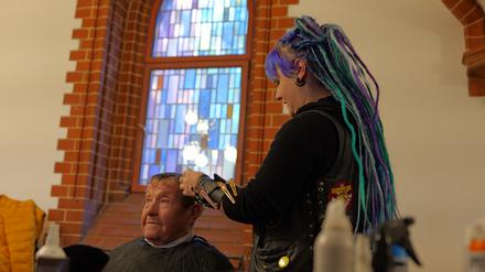 „Barber Angel“ Anni schneidet ihrem Gast Renate kostenlos die Haare in der Pauluskirche.