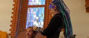 „Barber Angel“ Anni schneidet ihrem Gast Renate kostenlos die Haare in der Pauluskirche.