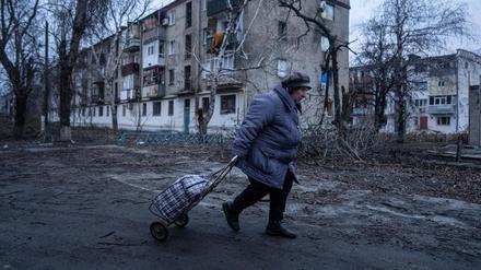 Ukraine, Kupjansk: Eine Einheimische geht zur Verteilungsstelle für humanitäre Hilfe vor einem Haus, das nach ukrainischen Angaben durch russischen Beschuss beschädigt wurde.