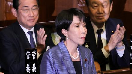 Die Vorsitzende der regierenden Liberaldemokratischen Partei Japans (LDP), Sanae Takaichi, steht, während ihre Parteikollegen applaudieren, nachdem sie am 21. Oktober 2025 im Unterhaus des Parlaments in Tokio zur Premierministerin gewählt wurde.
