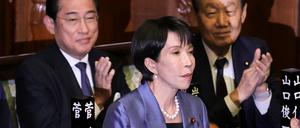 Die Vorsitzende der regierenden Liberaldemokratischen Partei Japans (LDP), Sanae Takaichi, steht, während ihre Parteikollegen applaudieren, nachdem sie am 21. Oktober 2025 im Unterhaus des Parlaments in Tokio zur Premierministerin gewählt wurde.