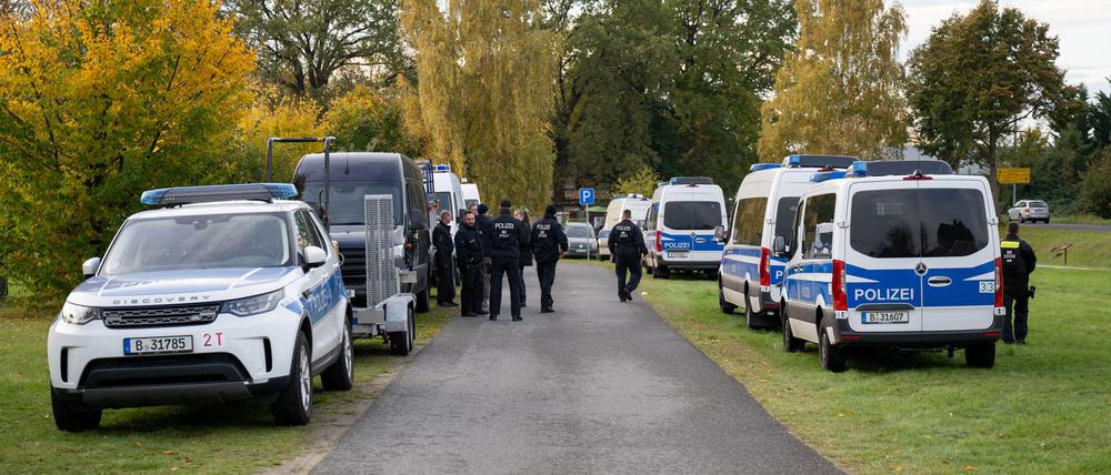 Polizeiautos stehen auf einer Wiese in Tauche.