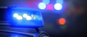 Ein Polizeiauto mit eingeschaltetem Blaulicht steht an einer Unfallstelle (Symbolbild).