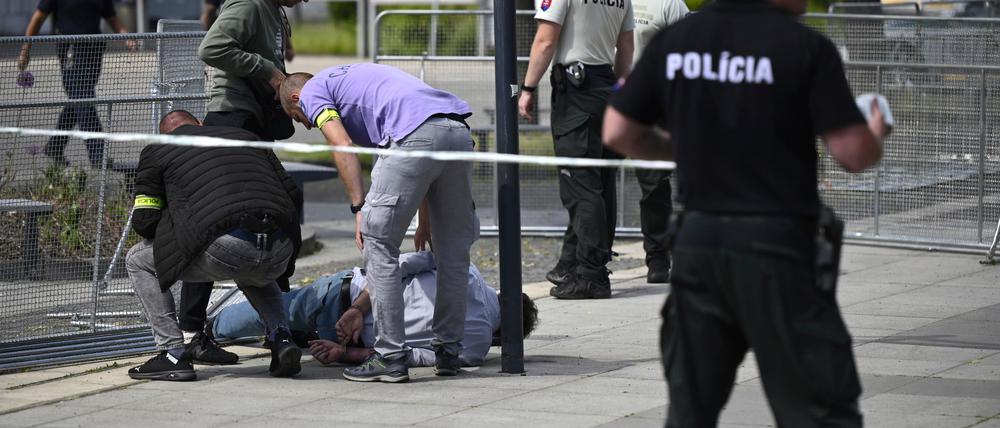 Polizisten nehmen einen Mann fest, nachdem der slowakische Ministerpräsident Fico nach einer Kabinettssitzung in der Stadt Handlova angeschossen und verletzt worden war (Archivbild).