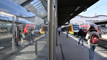 Reisende gehen auf dem Potsdamer Hauptbahnhof auf einen Regionalzug zu.