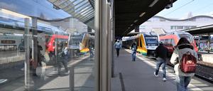 Reisende gehen auf dem Potsdamer Hauptbahnhof auf einen Regionalzug zu.