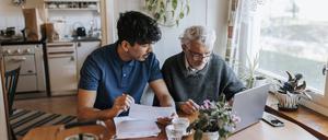 Ein junger Mann berät eine ältere Person (Symbolbild).