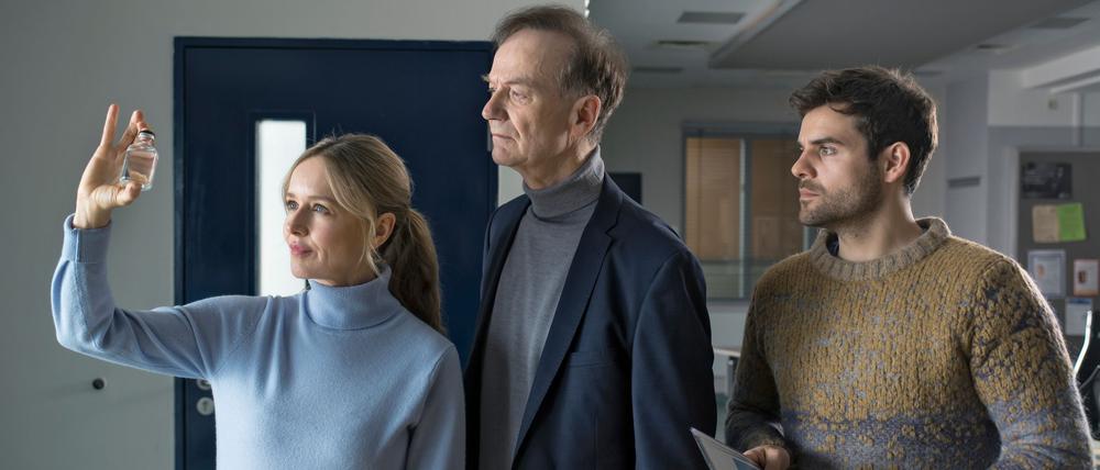 Die Kommissare Linett Wachow (Stefanie Stappenbeck, l-r), Reddemann (Arnfried Lerche) und Nils Makowski (Lucas Reiber) begutachten ein Fläschchen mit einem „Wundermittel“ in einer Szene aus der 100. Folge.