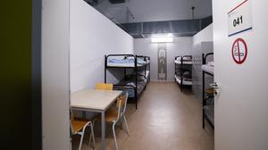 Blick in einen Raum mit Betten, Schränken und einem Tisch im sogenannten Dublin-Zentrum in Hamburg-Rahlstedt.