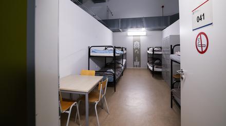 Blick in einen Raum mit Betten, Schränken und einem Tisch im sogenannten Dublin-Zentrum in Hamburg-Rahlstedt.