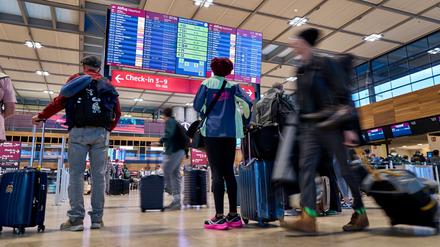 ARCHIV - 22.09.2025, Brandenburg, Schönefeld: Fluggäste informieren sich an den Abflugtafeln im Terminal 1 des Flughafens Berlin Brandenburg. (zu dpa: «BER bindet Airlines nach Cyberangriff wieder an IT-System an») Foto: Michael Ukas/dpa +++ dpa-Bildfunk +++