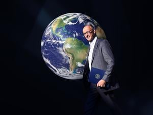 Friedrich Merz vor einer Weltkugel (Montage)