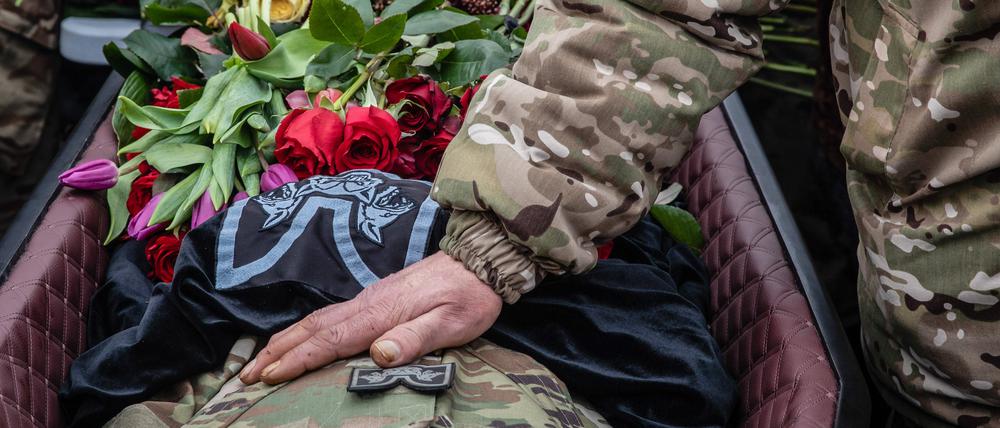 Ein Soldat am Sarg eines im Ukraine-Krieg gefallenen Soldaten (Symbolfoto).