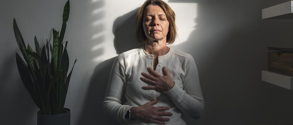 Eine Frau atmet bewusst durch: Wer sich Pausen und Ruhe gönnt, kann seine Werte verbessern.