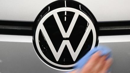 Eine Mitarbeiterin wischt über das VW-Logo auf einem ID.3 in der Monatgelinie im Werk von Volkswagen in Zwickau.