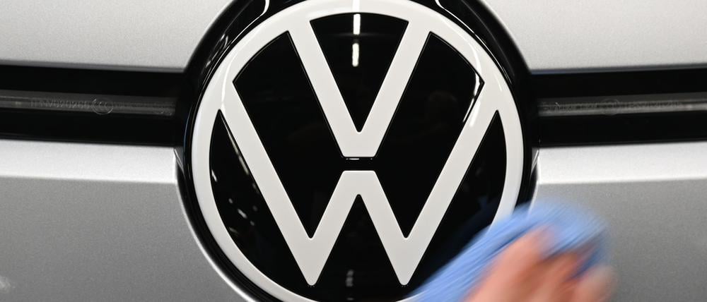 Eine Mitarbeiterin wischt über das VW-Logo auf einem ID.3 in der Monatgelinie im Werk von Volkswagen in Zwickau. 