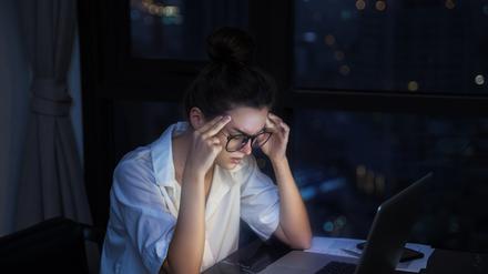 Overtime concept. Woman is working with laptop at home during night.