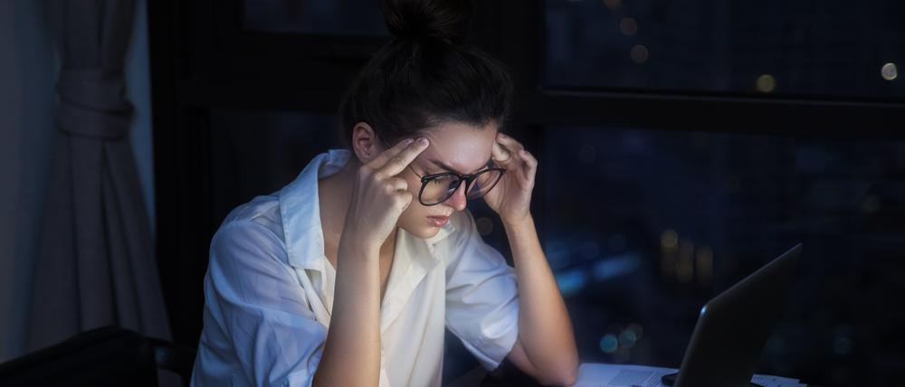 Overtime concept. Woman is working with laptop at home during night.