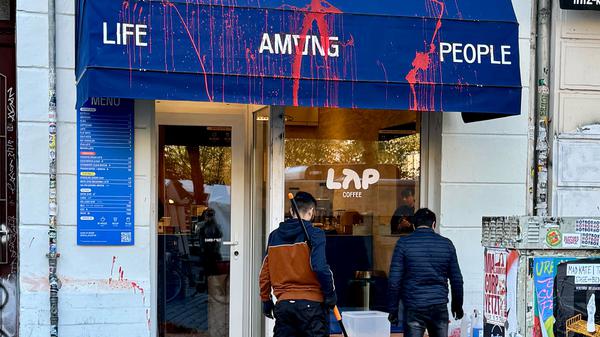 Nach mehreren Farbattacken auf Filialen der Kaffeekette LAP Coffee sind Mitarbeitende mit der Reinigung beschäftigt.
