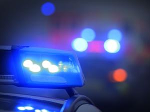 Ein Polizeiauto mit eingeschaltetem Blaulicht steht an einer Unfallstelle.