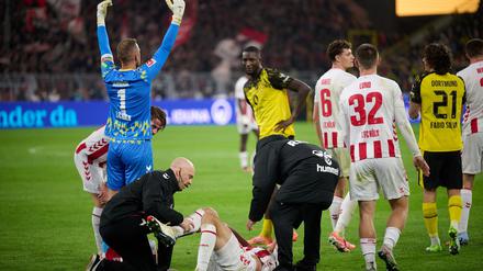 Kölns Timo Hübers wird auf dem Feld behandelt.