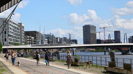 Passanten gehen auf dem Buenos-Aires-Kai am Baakenhafen in der Hafencity.