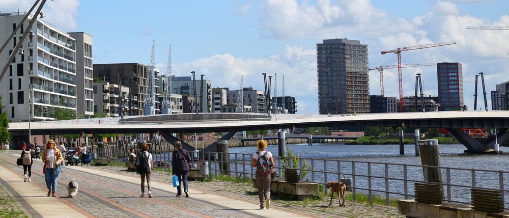 Passanten gehen auf dem Buenos-Aires-Kai am Baakenhafen in der Hafencity.