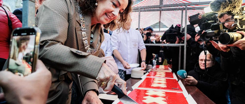 Amsterdams Bürgermeisterin Femke Halsema schneidet die lange Torte an.