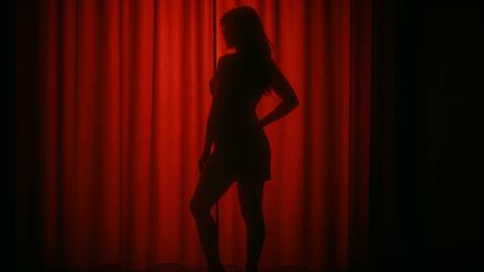Eine Frau steht vor einem roten Vorhang.
