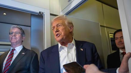 US-Präsident Donald Trump spricht, während US-Finanzminister Scott Bessent (links) und US-Außenminister Marco Rubio (rechts) zusehen, wie er an Bord der Air Force One auf dem Weg nach Japan am 27. Oktober 2025 mit den Medien spricht.