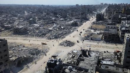 Auf diesem Drohnenfoto gehen Palästinenser über eine Kreuzung, die von Gebäuden umgeben ist, die während der zweijährigen Bombardierung durch die israelische Armee in der Stadt zerstört wurden.