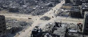 Auf diesem Drohnenfoto gehen Palästinenser über eine Kreuzung, die von Gebäuden umgeben ist, die während der zweijährigen Bombardierung durch die israelische Armee in der Stadt zerstört wurden.