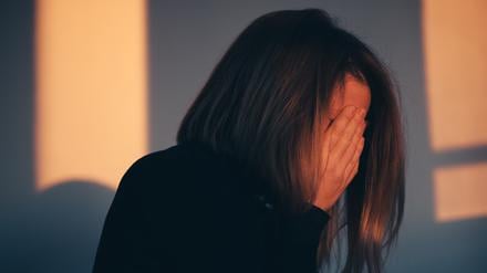A woman sitting alone and depressed in window light