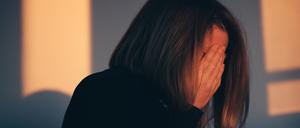 A woman sitting alone and depressed in window light